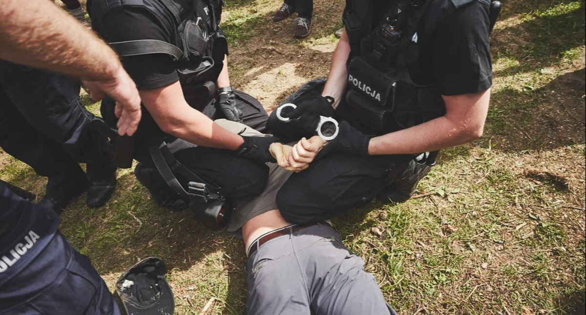 Zdjęcie policji dokonującej zatrzymania młodej osoby